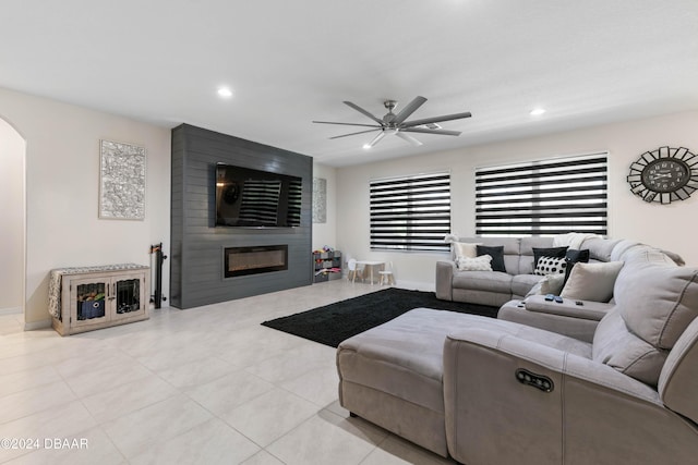 living room with ceiling fan and a large fireplace