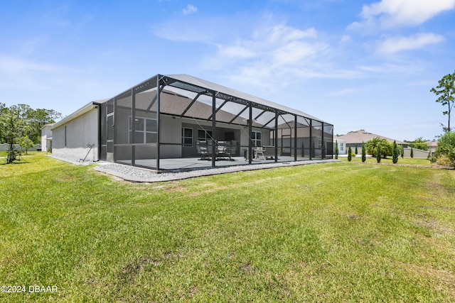 back of house featuring a lawn, a patio area, and a lanai