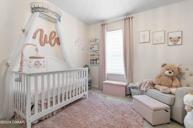 bedroom featuring a crib and light colored carpet