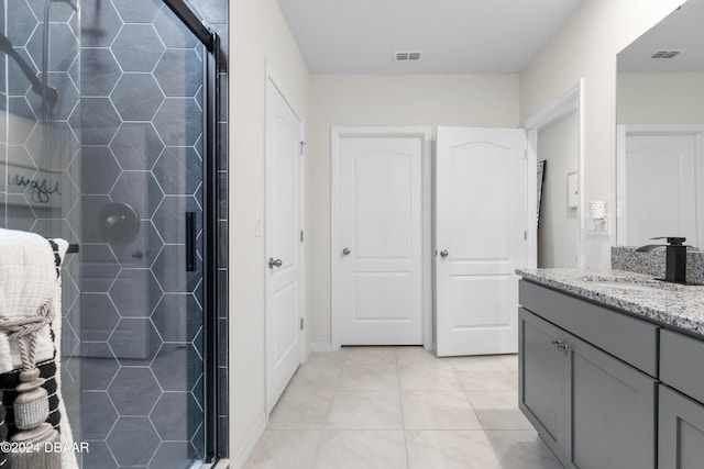 bathroom with tile patterned floors, vanity, and an enclosed shower