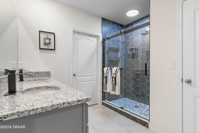 bathroom featuring tile patterned floors, vanity, and a shower with shower door