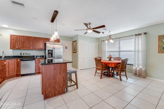 kitchen with pendant lighting, a center island, light tile patterned floors, and appliances with stainless steel finishes