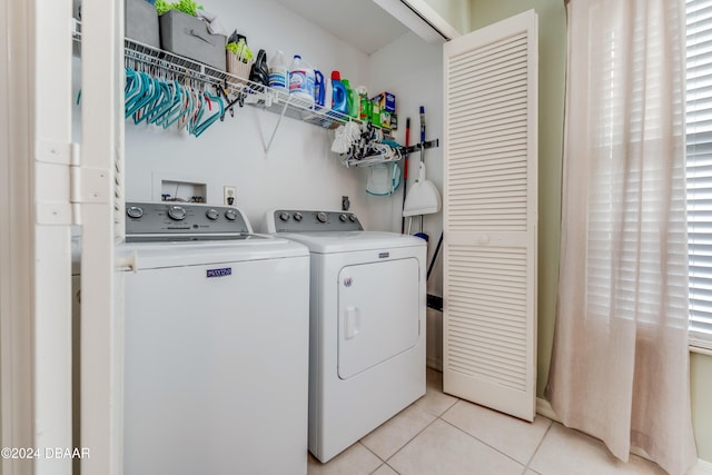 laundry room with independent washer and dryer and light tile patterned floors