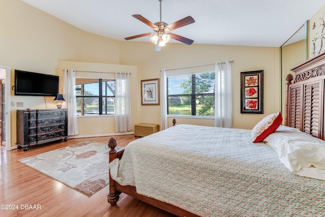 bedroom featuring hardwood / wood-style flooring, ceiling fan, vaulted ceiling, and multiple windows