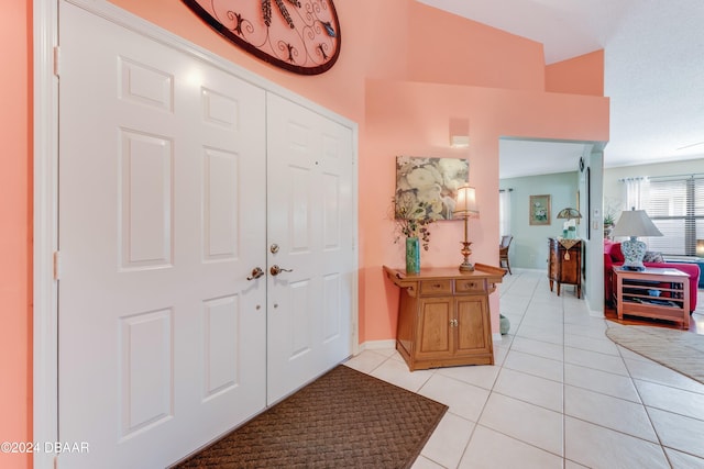 tiled foyer featuring lofted ceiling