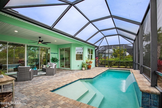 view of pool featuring outdoor lounge area, pool water feature, ceiling fan, a lanai, and a patio area