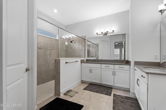 bathroom with tiled shower and vanity