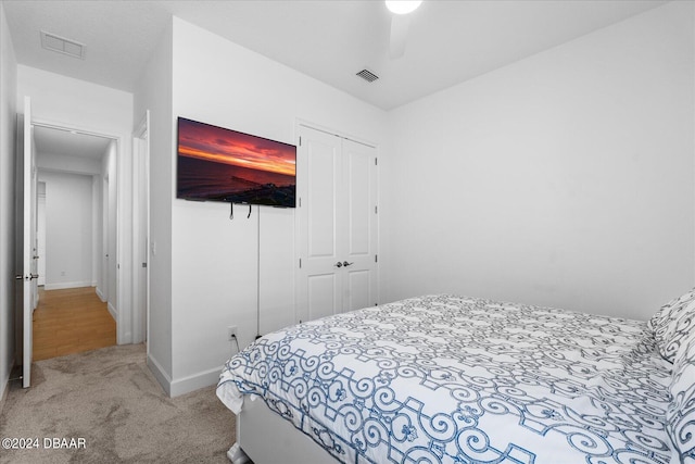 carpeted bedroom with ceiling fan and a closet