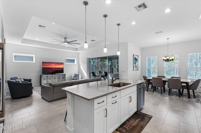 kitchen with white cabinets, hanging light fixtures, sink, an island with sink, and stainless steel dishwasher