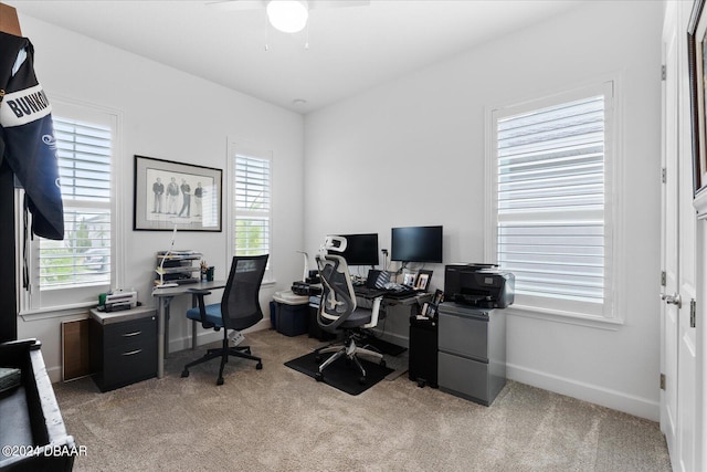 home office featuring light carpet and ceiling fan