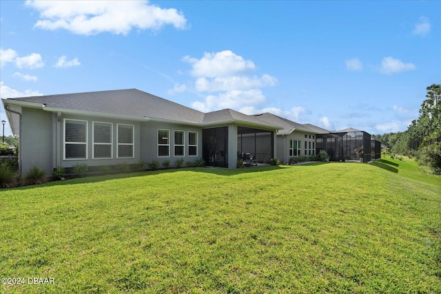 rear view of house featuring glass enclosure, a lawn, and a sunroom