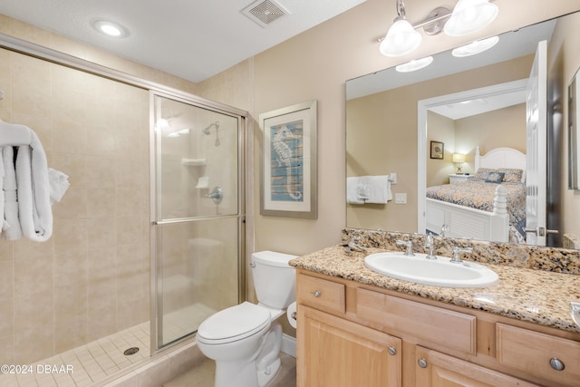 bathroom featuring vanity, an enclosed shower, and toilet