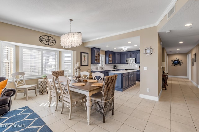 dining area with sink, crown molding, a chandelier, a textured ceiling, and light tile patterned floors