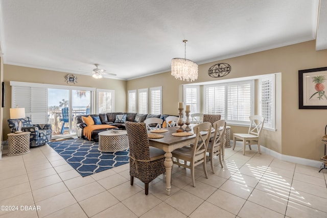 tiled dining space with a textured ceiling, ceiling fan with notable chandelier, and crown molding