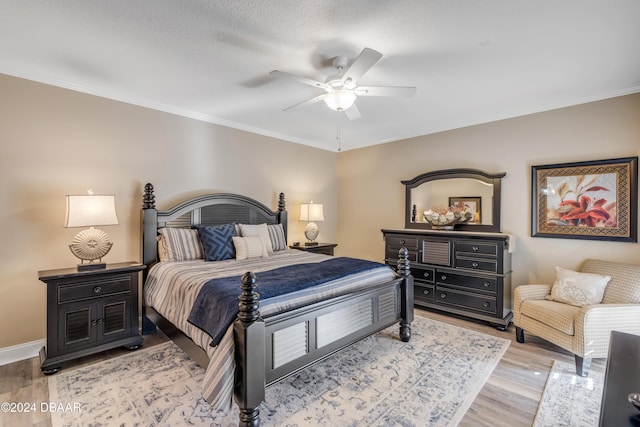 bedroom with a textured ceiling, ceiling fan, light hardwood / wood-style floors, and crown molding