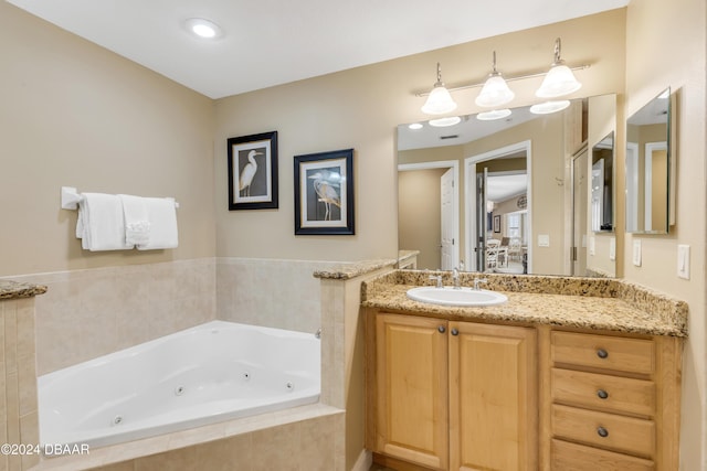 bathroom with a relaxing tiled tub and vanity