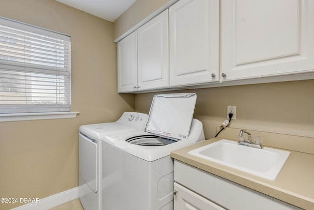 laundry area featuring cabinets, independent washer and dryer, and sink