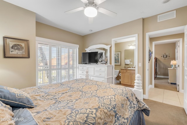 bedroom featuring ensuite bathroom, ceiling fan, and light colored carpet