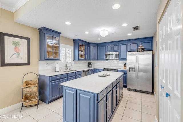 kitchen featuring backsplash, blue cabinets, sink, a kitchen island, and stainless steel appliances