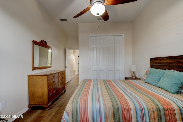 bedroom with dark hardwood / wood-style flooring, a closet, and ceiling fan