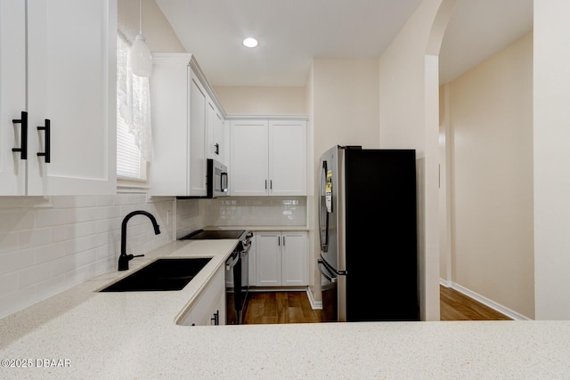 kitchen featuring sink, dark wood-type flooring, stainless steel appliances, tasteful backsplash, and white cabinets