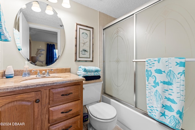 full bathroom featuring vanity, enclosed tub / shower combo, a textured ceiling, and toilet