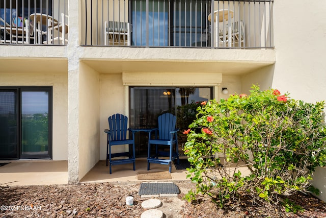 property entrance with a patio area and a balcony