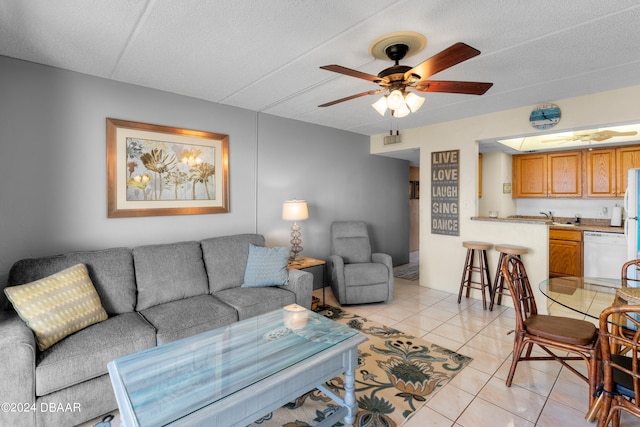 living room featuring a textured ceiling, light tile patterned flooring, and ceiling fan