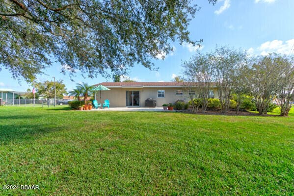 back of house with a yard and a patio