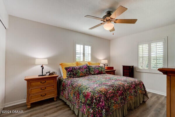 bedroom featuring multiple windows, ceiling fan, and dark hardwood / wood-style floors