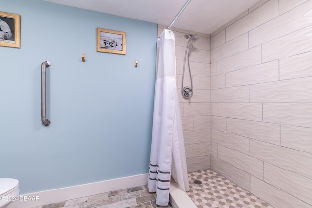 bathroom featuring a shower with shower curtain and toilet