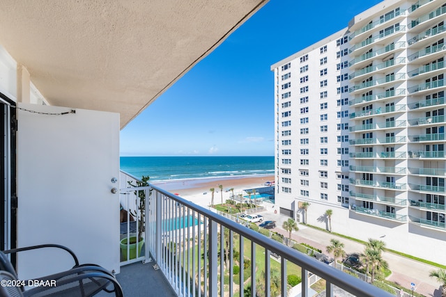 balcony with a water view and a view of the beach