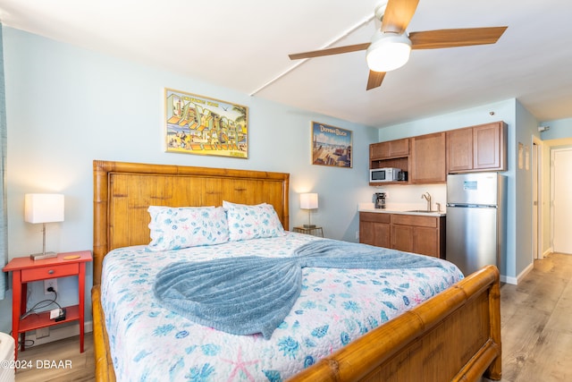 bedroom with ceiling fan, stainless steel refrigerator, sink, and light wood-type flooring