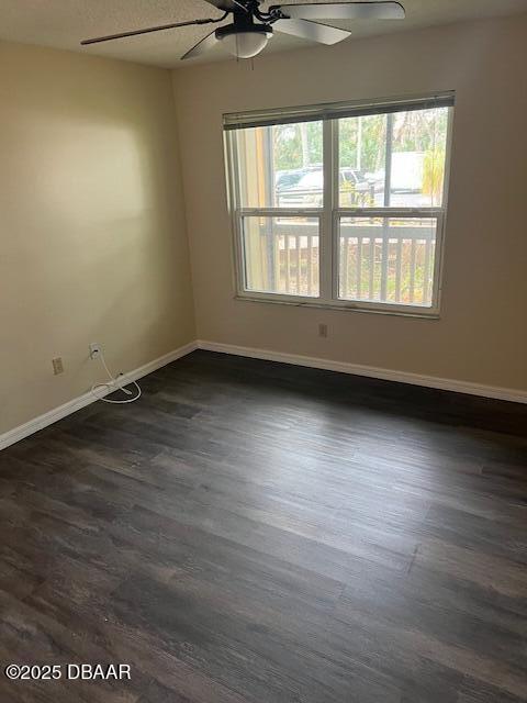 unfurnished room with ceiling fan and dark hardwood / wood-style flooring