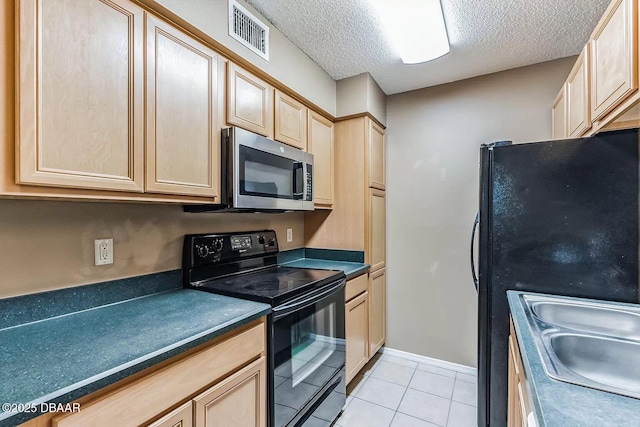 kitchen with light tile patterned floors, sink, light brown cabinetry, and black appliances