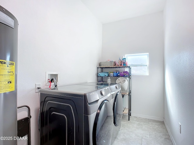 clothes washing area featuring independent washer and dryer and water heater