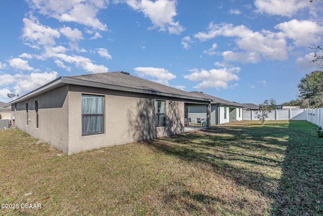 back of property with a yard, central AC, a fenced backyard, and stucco siding