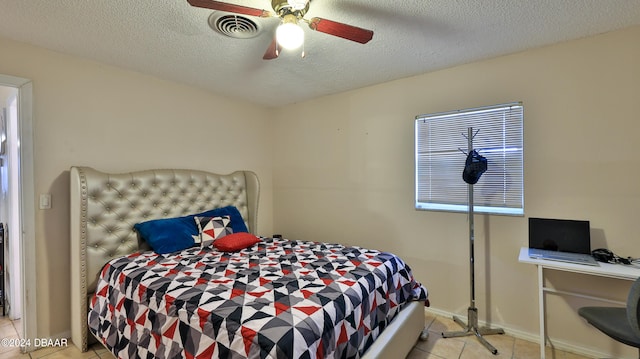 bedroom with a textured ceiling, light tile patterned floors, and ceiling fan