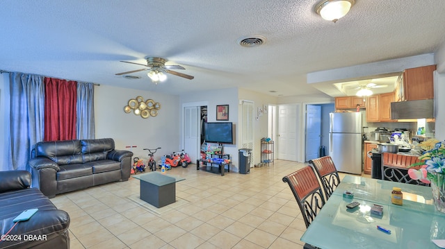 tiled living room with a textured ceiling and ceiling fan