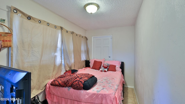 bedroom featuring a textured ceiling and tile patterned flooring