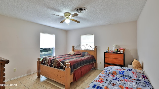 tiled bedroom with a textured ceiling and ceiling fan