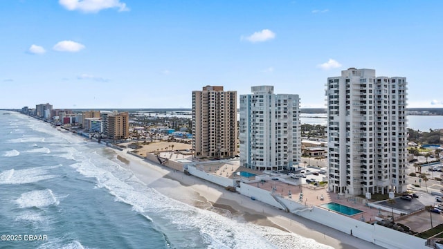 aerial view featuring a view of city, a beach view, and a water view