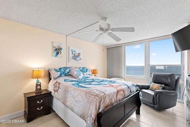 bedroom with a textured ceiling, ceiling fan, light tile patterned floors, and baseboards