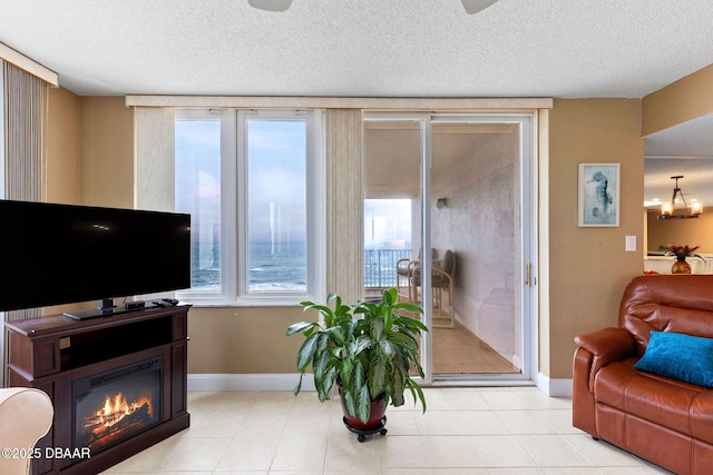 living room featuring a glass covered fireplace, plenty of natural light, and a textured ceiling