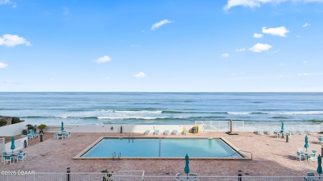 property view of water with fence and a beach view