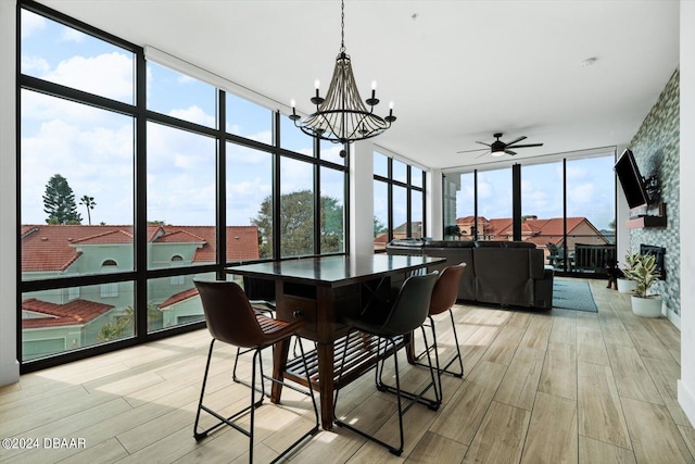 sunroom featuring a wealth of natural light and ceiling fan with notable chandelier