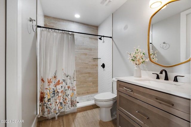 bathroom with toilet, a shower with shower curtain, wood-type flooring, and vanity