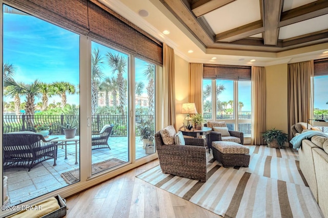 living area with beam ceiling, crown molding, recessed lighting, wood finished floors, and coffered ceiling