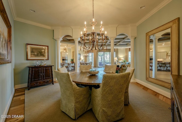 dining area featuring baseboards, wood finished floors, an inviting chandelier, crown molding, and ornate columns