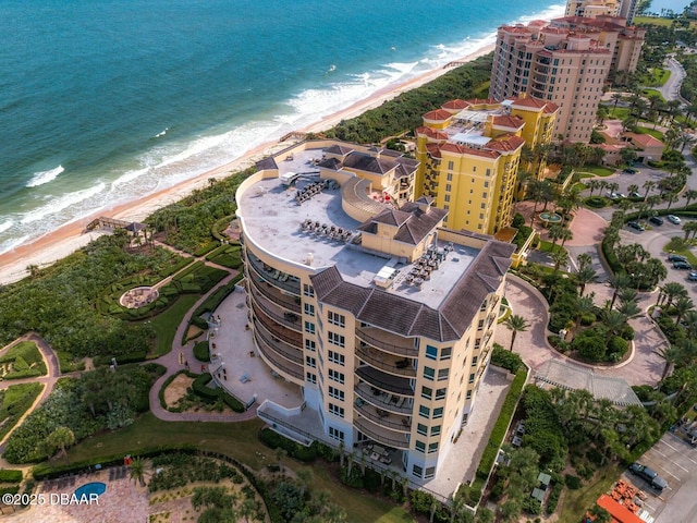 birds eye view of property featuring a water view, a view of the beach, and a city view